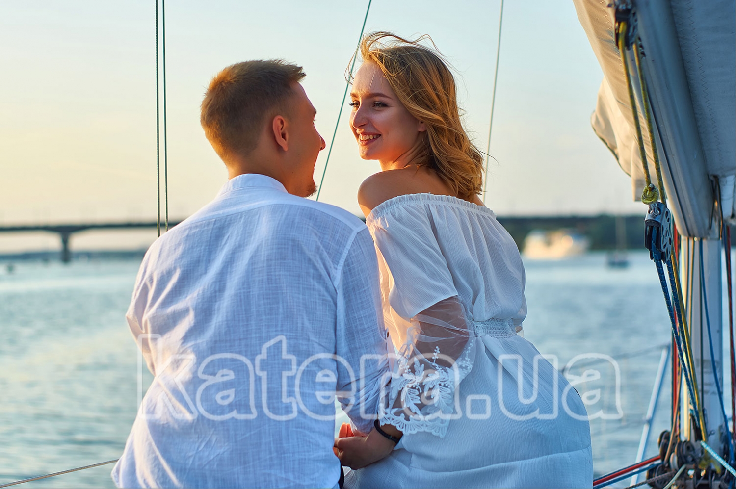 Парень и девушка держатся за руки на яхте Александра и смотрят друг другу в глаза - katera.ua